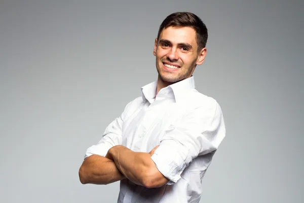 Retrato de jovem sorridente feliz homem de negócios, isolado sobre fundo cinza — Fotografia de Stock