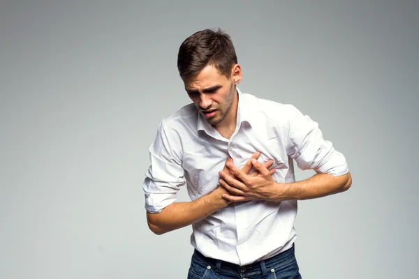 Businessman holding his heart in pain Stock Photo