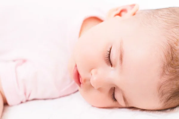 Adorable et beau portrait en gros plan de bébé fille dormant sur lit blanc . — Photo
