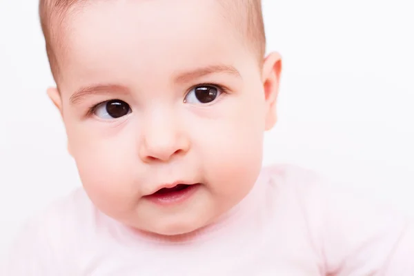 Bonito rosto interessado do bebê que olha para um lado no fundo branco — Fotografia de Stock