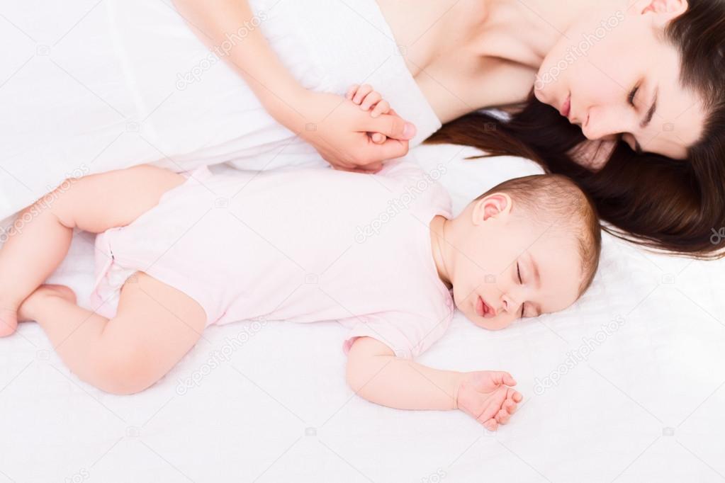 Beautiful sleeping mom with baby on white background