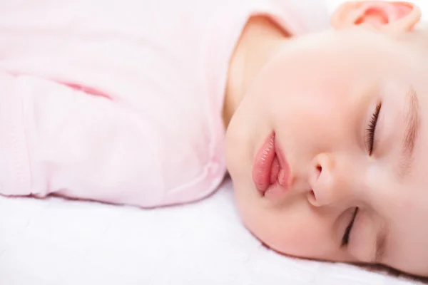 Adorable slapende baby op wit met roze pak — Stockfoto