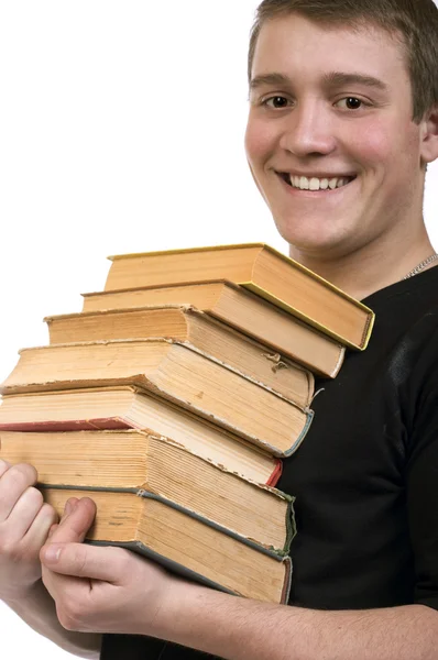 Een jonge man draagt een stapel boeken — Stockfoto