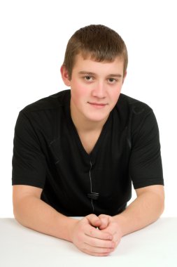 Genç adam beyaz bir arka plan üzerinde siyah gömlekli bir masada oturur