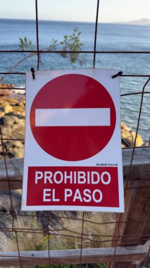 Beyaz çubuklu kırmızı daire, aşağıda kalın metin. Beyaz harflerle 