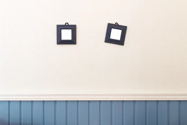 Dwa małe kwadratowe ramki wiszące na ścianie biały i niebieski. — Zdjęcie stockowe