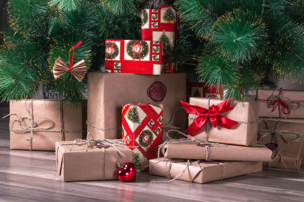 Завернутые подарки лежат под елкой
