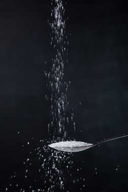 Pile of white sugar in a teaspoon clipart