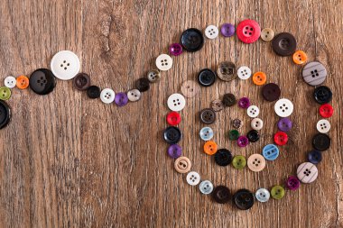 Helix ahşap arka plan üzerinde renkli dikiş düğmeleri