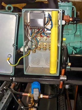 Close-up of an open electrical panel revealing a complex arrangement of wires, connectors, and other components, likely for industrial machinery.