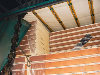 Yeni izole paneller plastiğe sarılı ve inşaat alanına taşınmaya hazır.