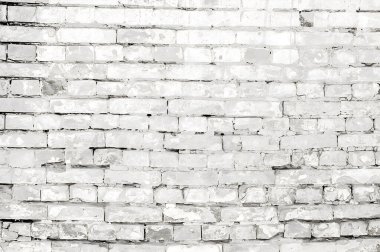Eski beyaz tuğlalı bir duvarın yakın plan görüntüsü desenli yüzeyi, çatlak boyası ve görünür havan hatlarını sergiliyor.