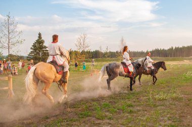 Kyiv, Ukrayna. 6 Temmuz 2013. Geleneksel giysiler içindeki insanlar, Kiev yakınlarındaki bir parkta düzenlenen Ivan Kupala kutlamaları sırasında bir at turnuvasına katılıyorlar.