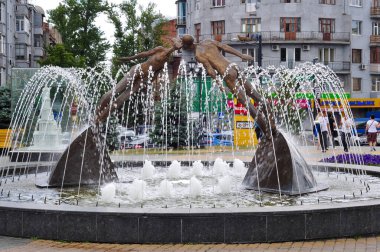 Odesa, Ukrayna. 3 Ekim 2016. Öpüşmek üzere gibi görünen dinamik duruş içinde iki figürden oluşan çarpıcı bir bronz heykel, Ukrayna 'nın Odesa kentinde çağlayan su akıntıları ve jetleriyle bir halk çeşmesinin merkezinde yer alıyor.