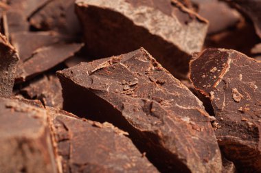 Detaylı bir makro çekim, kaba, kırık kenarları ve koyu kahverengi renkli siyah çikolata parçalarını bir araya getiriyor.