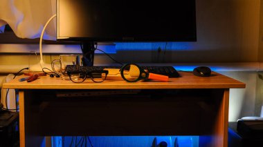 Ahşap bir masa yüzeyi sıcak ve serin ortam ışıklarıyla aydınlatılır, çeşitli çalışmalar ve çalışmalar gösterilir.