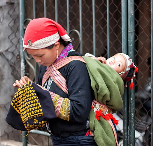 SAPA, VIETNAM-FEBRUARY 11: mother and child Hmong of Sapa on February 11, 2012 in Sapa. Двухлетний мальчик по имени Вангку.Хмонги известны своими красными костюмами и украшенными серебряными украшениями — стоковое фото