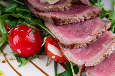 Orta az pişmiş biftek bir tabakta sebze ve peynir ile servis