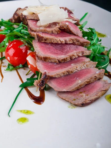 Medium rare steak served on a plate with vegetables and cheese — Stock Photo, Image