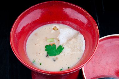 Siyah ahşap bir masa kırmızı bir bardakta servis sebze çorbası