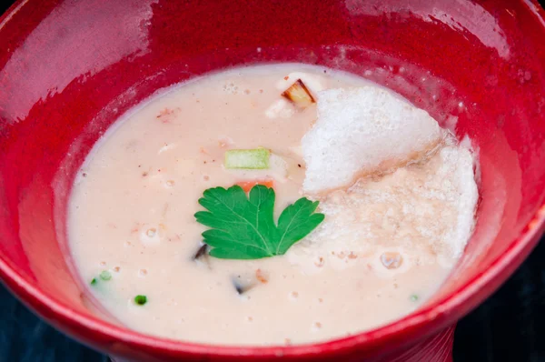 Siyah ahşap bir masa kırmızı bir bardakta servis sebze çorbası