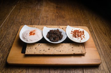 Ahşap bir masaya servis üç farklı sos