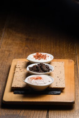 Ahşap bir masaya servis üç farklı sos