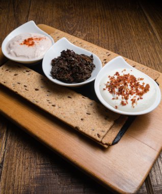 Ahşap bir masaya servis üç farklı sos