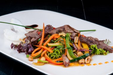 Kıyılmış et ile birlikte beyaz bir tabakta sebze