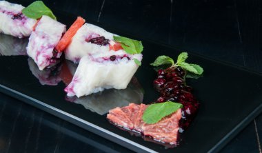 Siyah bir tabakta blackberry ile tatlı suşi rulo