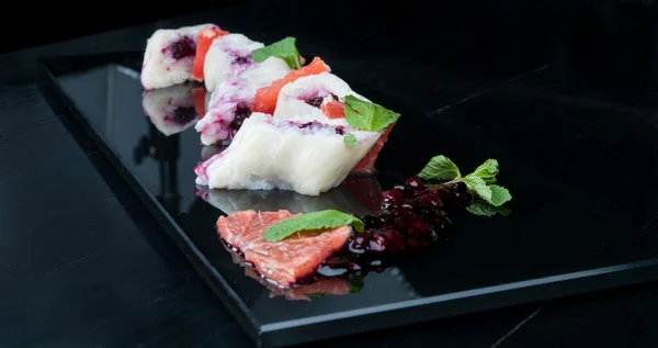 Rollos de sushi dulce con mora servido en un plato negro — Foto de Stock