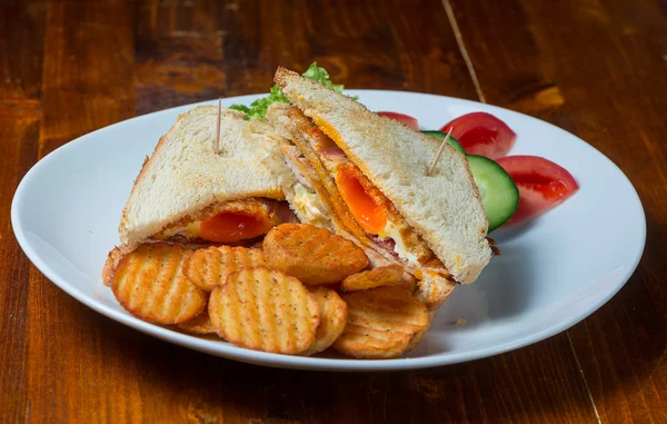 Sandwich con huevos y jamón, servido en un plato blanco — Foto de Stock