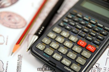 Gözüne gözlük, kalem ve kurşun kalem formülü ile hesap makinesi üzerinde