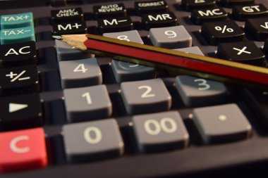 Gözüne gözlük, kalem ve kurşun kalem formülü ile hesap makinesi üzerinde