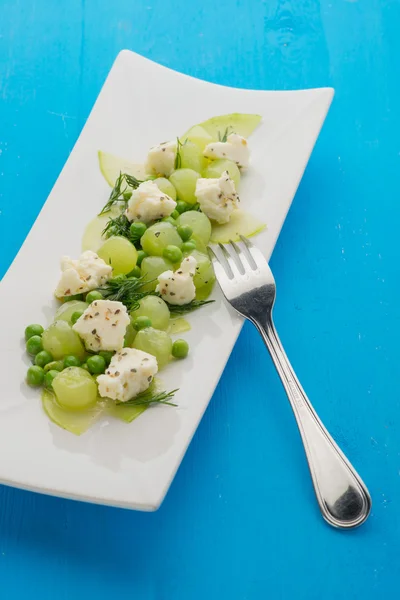 Läckra druvor sallad med ärtor och ost på blå tabell — Stockfoto