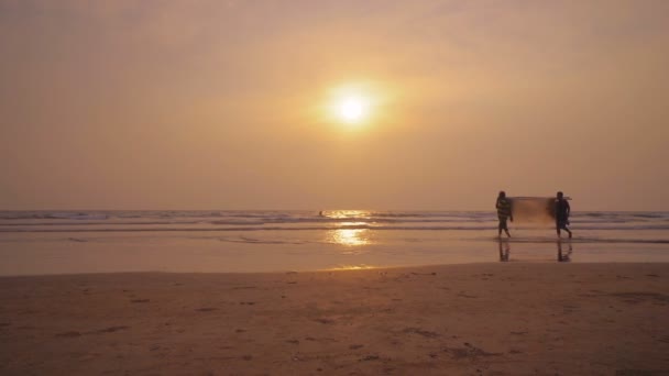 Silhouettes fisherman working with fishing net, sunset time — Stock Video