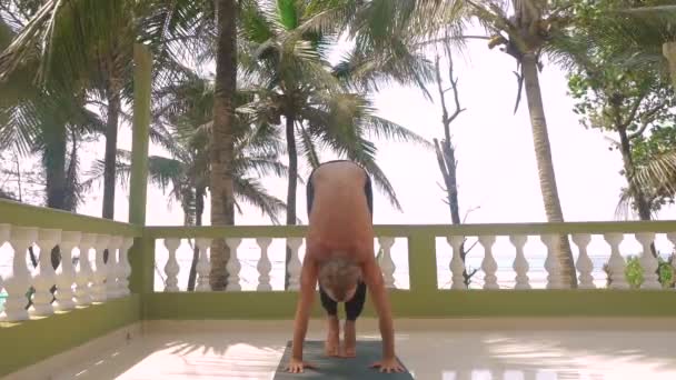 Jonge slanke man doen ashtanga yoga in India — Stockvideo