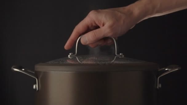 Hand open lid on steaming pot — Stock Video