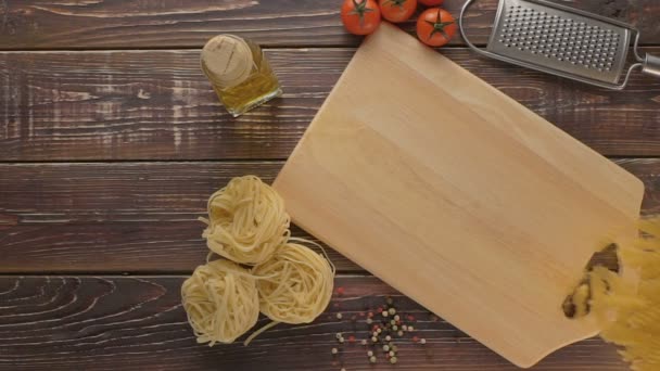 Pasta en ingrediënten op donkere houten achtergrond. — Stockvideo