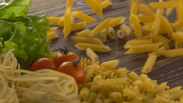 Pasta en ingrediënten op donkere houten achtergrond. — Stockvideo