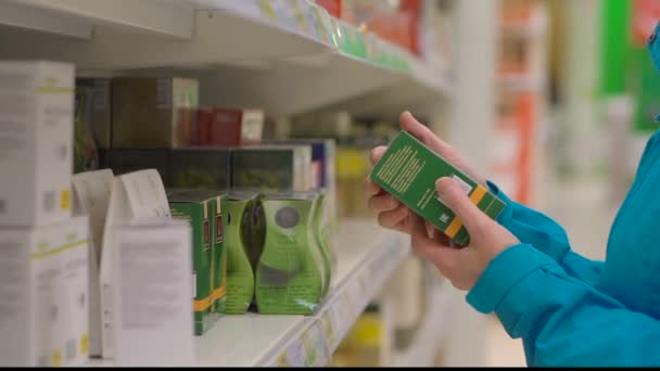 Женщина выбирает зеленый чай во время покупок в супермаркете — стоковое видео