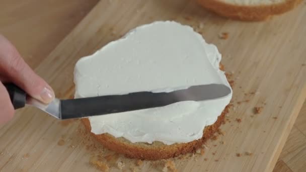 Putting butter cream cake by hand using spatula — Stock Video