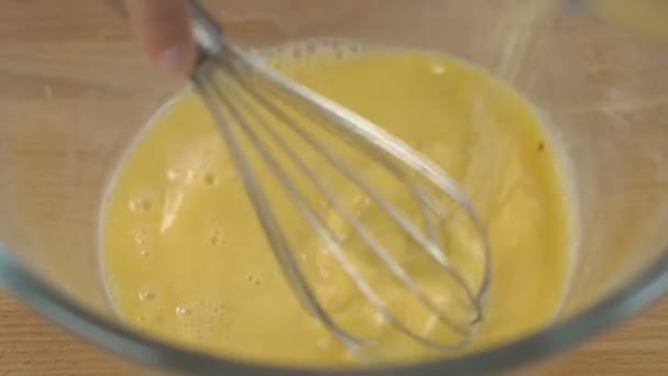 Beaten Eggs with Whisks in Bowl. Sugar being pouring into bowl. — Stockvideo