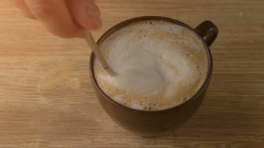 Cappuccino kahve köpüğü kaşıkla karıştırma el yakın çekim