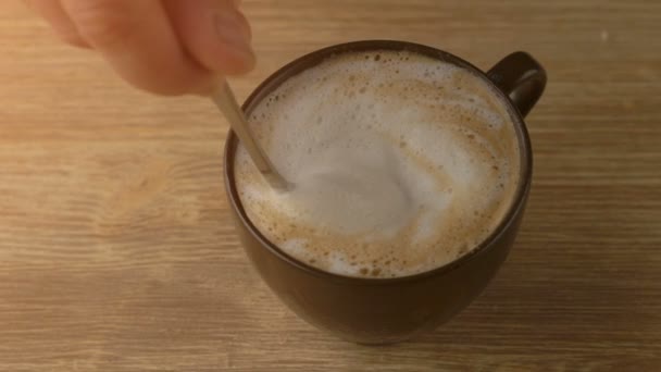 Close up of hand mixing cappuccino coffee foam with spoon — Stock Video