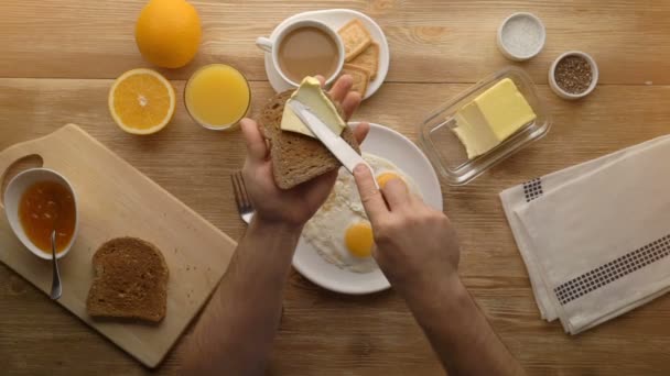 Man hands preparing breakfast toast with butter, top view — Stock Video