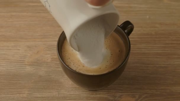 Cafetière versant du lait chaud dans une tasse pour préparer le cappuccino — Video