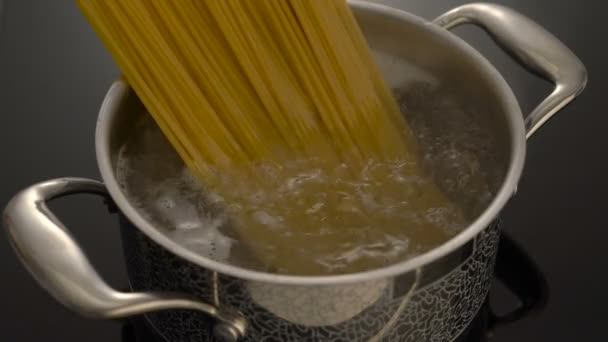 Vařící špagety v pánvi na elektrickém sporáku v kuchyni