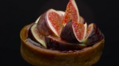 Taze incirli ev yapımı tart ve siyah arka planda bal, lezzetli tartalet tatlısına yakın plan.