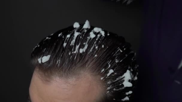 Master parrucchiere rende lo styling dei capelli con spray mousse e spazzola per capelli per il cliente maschile presso il barbiere — Video Stock